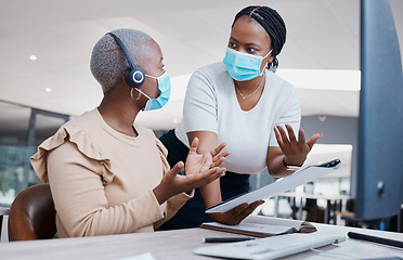 Image showing Manager consulting a call center agent about business paperwork with face masks in covid pandemic. Black, young and customer support worker discussing a work mistake with her mentor in an office.