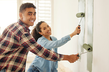 Image showing Happy couple painting for renovation with a brush in the living room at home. Portrait of a creative man and woman with a smile add paint on wall in the lounge for home improvement and maintenance