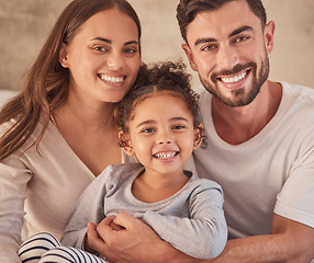 Image showing Happy family, girl and an interracial couple smiling and excited about spending quality time together. Portrait of parents, mother and father having fun with their adopted daughter at home