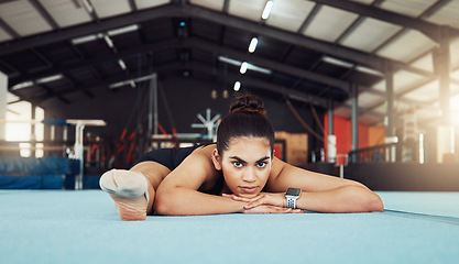 Image showing Woman stretching on floor at health gym, doing workout exercise at sports club and training for fitness. Portrait of an athlete or gymnast doing gymnastics on floor, yoga for wellness and body