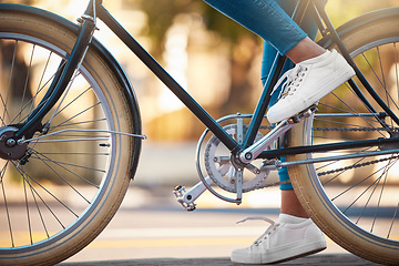 Image showing Bike, shoes and cycling with a woman cyclist riding her bicycle outside on the road or street during the day. Sport, exercise and fitness with a female rider on transport with wheels and pedals