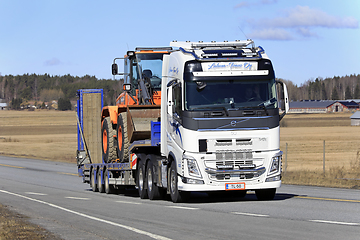 Image showing White Volvo Truck Hauls Wheel Loader