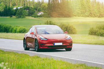 Image showing Red Tesla Model 3 Electric Car on Sunny Road