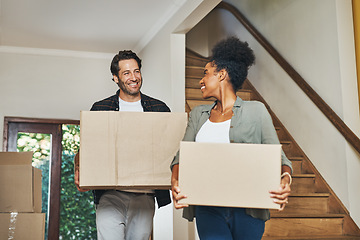 Image showing Couple homeowners moving in, carrying boxes and unpacking in new purchased home as real estate investors. Smiling, happy and cheerful interracial man and woman, first time buyers and property owners