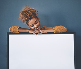 Image showing Blank white poster and copyspace of a smiling, happy and young woman holding the sign. Female looking at an empty copy space board with a retail sale, marketing or social media advertising indoors