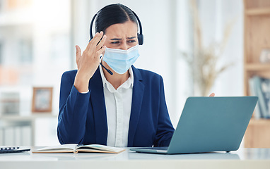 Image showing Headache, pain and tired call center agent working on a laptop with headset while wearing face mask. Stressed, burnout and frustrated customer service woman working on computer in a corporate office