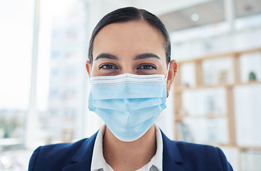 Image showing Safety, compliance and face mask covid regulations at work with a young employee in an office. Corporate professional smiling and looking positive, enjoying her career and hygiene at the workplace