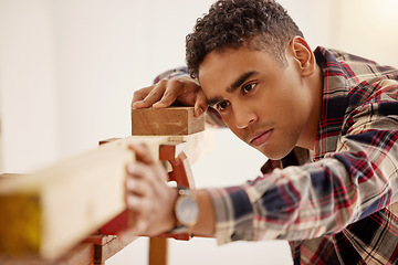 Image showing Wood, construction and project with a carpenter man doing DIY with sandpaper in his home for building, renovation and improvement. Carpentry, contractor and maintenance with a young male handyman