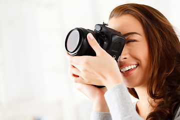 Image showing Happy woman photographer doing a photoshoot with a camera in a studio with copy space. Art, creative and young lady with a photography career taking a picture for a artistic work project.