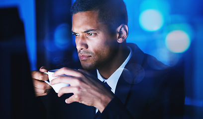 Image showing Businessman drinking a cup of coffee while working overtime in the office at night time. Corporate, company and professional manager sitting at desk and analyzing data, documents and reports at work.