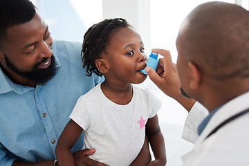 Image showing Doctor helping a child patient with an asthma inhaler in his office at the medical clinic. Healthcare worker consulting a girl with chest or respiratory problems with pump in a childrens hospital