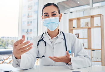 Image showing Doctor with covid face mask talking on video conference, consulting on a video call and teaching health on webinar at hospital. Portrait of healthcare worker in discussion about medical insurance