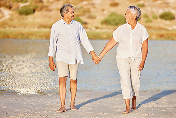 Image showing Love, walking and senior couple on a beach lake together for calm, relax and romantic ocean, water or sea date. Elderly happy people, man and woman smile while living pension and retirement lifestyle