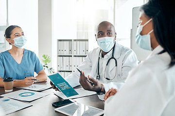 Image showing Team of doctors with face mask consulting on covid results with paperwork and a digital tablet. Healthcare workers in a meeting to discuss the vaccine, treatment and medicine in a hospital office.