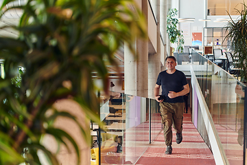 Image showing In the hustle and bustle of a modern startup office, a determined businessman sprints towards his office, embodying the fast-paced, ambitious spirit of contemporary entrepreneurship