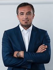 Image showing Young beautiful focused european businessman. Front view of man with dark hair clothing casual business formal jacket Isolated on gray background