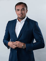 Image showing Young beautiful focused european businessman. Front view of man with dark hair clothing casual business formal jacket Isolated on gray background