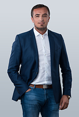 Image showing Young beautiful focused european businessman. Front view of man with dark hair clothing casual business formal jacket Isolated on gray background