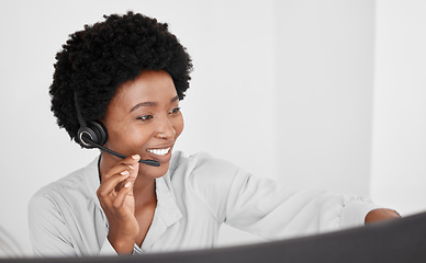 Image showing Call center consultant in communication online on computer, consulting with people on the internet and support in customer care job at telemarketing company. Happy African receptionist on phone call