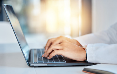 Image showing Doctor hands typing on a laptop doing medicine research at a hospital table and reading email online at work. Healthcare expert or medical professional using keyboard and consulting via the internet