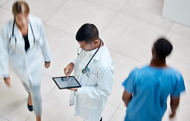 Image showing Tablet, healthcare and medicine with a man doctor working in a busy hospital with urgency. Medical, research and insurance with professional workers in medicine rushing with blur in a clinic