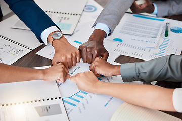 Image showing Hands, teamwork and meeting with a team working in collaboration with paperwork and data and their fists in a circle. Finance, strategy and growth with a group of business people in the boardroom