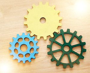 Image showing Collaboration, engineering and construction concept with industrial gears, mechanics and cogs on a table or desk in an office. Teamwork, synergy and industry with the idea of building or design