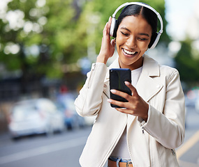 Image showing Happy city girl with phone and headphones listening to music, podcast or streaming a online subscription service movie. Black woman watching funny web comedy, internet meme or social media app video