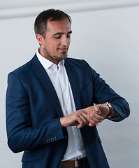 Image showing Young beautiful focused european businessman. Front view of man with dark hair clothing casual business formal jacket Isolated on gray background