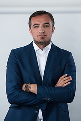 Image showing Young beautiful focused european businessman. Front view of man with dark hair clothing casual business formal jacket Isolated on gray background