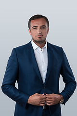 Image showing Young beautiful focused european businessman. Front view of man with dark hair clothing casual business formal jacket Isolated on gray background