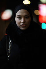 Image showing Muslim woman walking on urban city street on a cold winter night