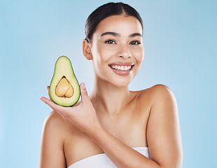 Image showing Skincare, health and avocado with a woman portrait on studio blue background and mockup. Young model with healthy fruit nutrition for face, skin care ingredients and clean, perfect or natural results
