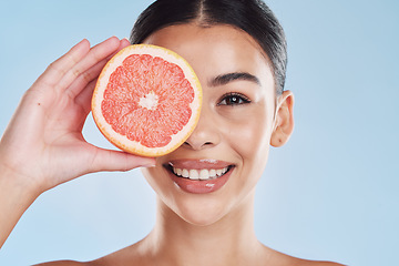 Image showing Portrait of woman with happy face and grapefruit in blue studio background. Her skincare and wellness beauty routine keeps her body fresh or healthy dental hygiene and clean smile or white teeth