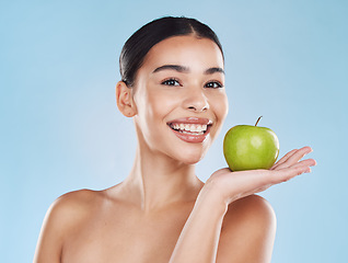 Image showing Wellness, health and beauty with woman and an apple for nutrition, detox and green diet against a blue background. Nutritionist, smile and fruit with happy female eating healthy for natural lifestyle