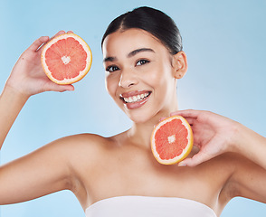 Image showing Grapefruit, skincare, face and diet wellness keeps her happy and healthy for skin healthcare, eat healthy fruit with nutrition. Portrait of a beauty woman in studio against a blue background