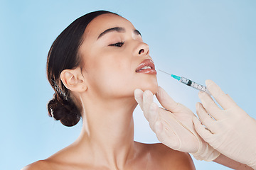 Image showing Plastic surgery, collagen and lip filler for beauty aesthetic goal, youth and young face or facial appearance. Cosmetic surgery doctor hands work on woman, patient or client lips with blue background