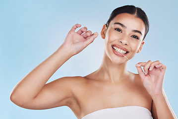 Image showing Oral, dental and flossing woman cleaning teeth in a studio blue background mockup. Young model with white or perfect smile, clean mouth or gums portrait for hygiene, healthcare and dentistry mock up