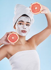 Image showing Skincare, health and face mask on a woman with a grapefruit doing an organic facial in studio. Girl with wellness, selfcare and healthy lifestyle doing a body care routine with tropical citrus fruit.