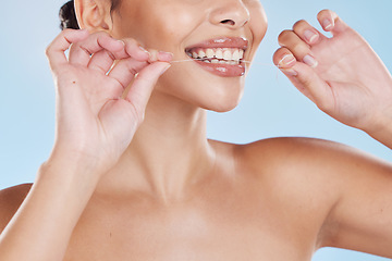 Image showing Healthcare, dental hygiene and a woman flossing her teeth with a smile. Wellness routine, health and floss in hands, happy to take care of your mouth to avoid trip to dentist, with a blue background.