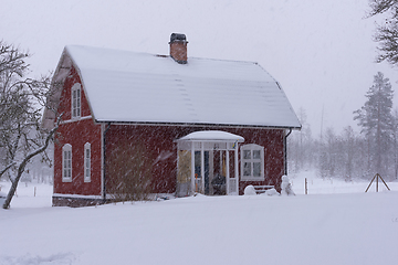 Image showing Red wooden house in snowdrift