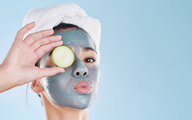 Image showing Beauty, cosmetics and skincare by woman grooming with a face treatment and cucumber against studio background. Young female enjoy self care and organic products during routine pamper wellness session