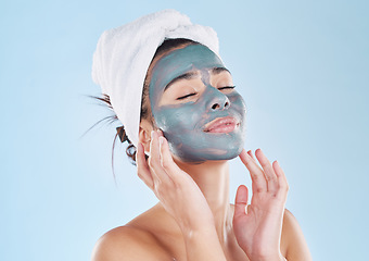 Image showing Skincare, body wellness and charcoal face mask for healthy woman skin against blue mockup studio background. Young, happy and beauty cosmetic model with antiaging product for wellbeing and grooming