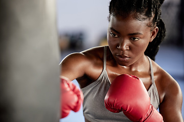 Image showing Woman, boxing and gym training workout for strong and motivated athlete fighter fitness. Hand coordination, focus and concentration for punching bag strike exercise in sports facility.