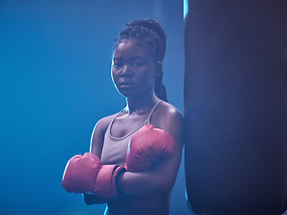 Image showing Fitness, boxer and gym of a black woman in sports professional for strength and motivation. Portrait of a African female in serious and confident boxing at health club standing by punching bag