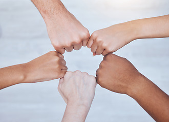 Image showing Fist bump, unity and support group touching hands in a circle at a community therapy session. Top view of friends doing team building, care and trust exercise while bonding at a fellowship event.
