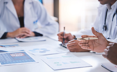 Image showing Team, medical analysts and doctors consulting with paperwork of graphs, data and charts in hospital conference room. Closeup of healthcare staff discussing statistics, results and innovation strategy