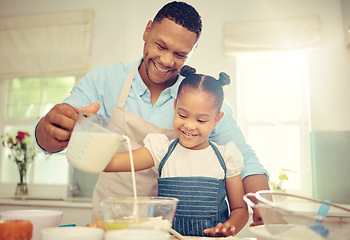 Image showing Father teaching girl to bake and make dough in a messy kitchen. Caring parent and little daughter baking together in home while pouring milk into a bowl while having fun and bonding together.