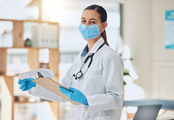 Image showing Portrait of a doctor with paper and face mask doing medical paperwork during covid pandemic. Healthcare worker reading coronavirus results on a clipboard of hospital patient while standing in clinic.