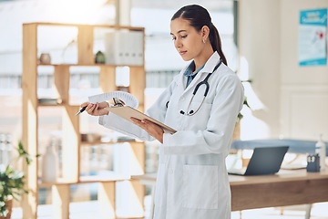 Image showing Insurance, healthcare and medicine with a doctor reading paperwork in a clipboard in her office in the hospital. Medical, review and wellness with a female professional in the health industry